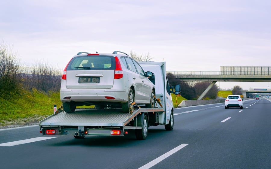 Silver Car on a Tow Truck on the Road